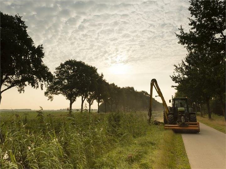 Een medewerker voert maaiwerkzaamheden uit Een medewerker voert maaiwerkzaamheden uit